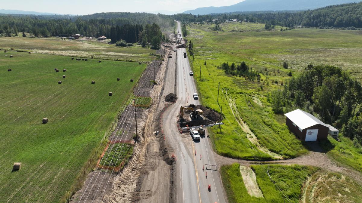 Aerial view of a culvert installation on a live rural highway beside hay fields